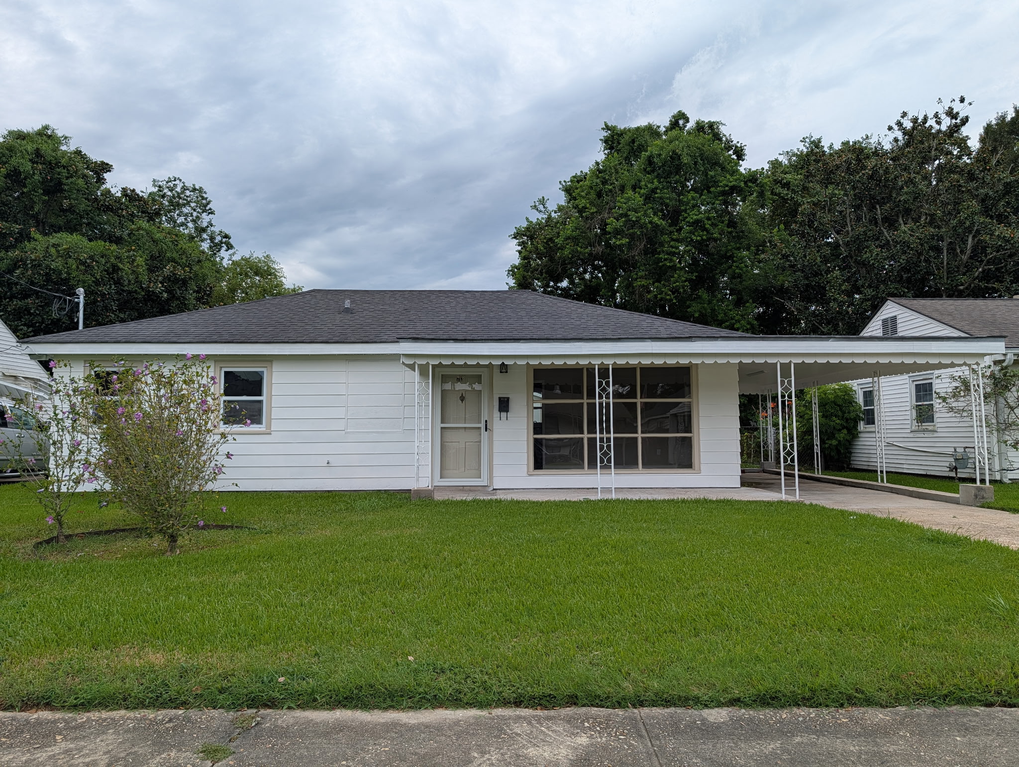White single-story home with a covered front porch and green lawn